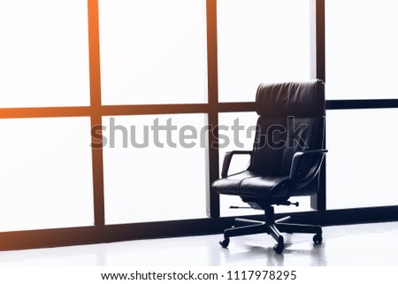 Black executive leather chair in empty office space with large window ,copy space. Royalty-Free Stock Photo #1117978295