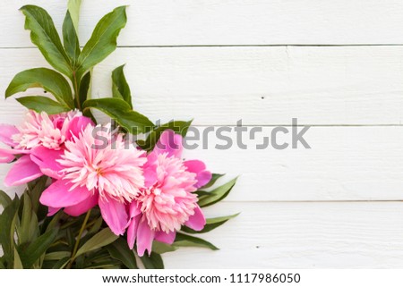 Bunch, bouquet of pink peonies on a wooden background. Frame of flowers. Colorful background