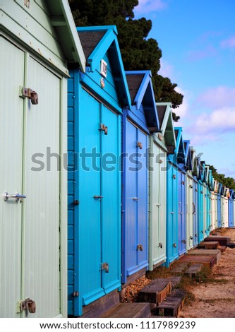  English seaside wooden huts, Mudeford, South of England. One of the unique thing and symbol of British Seaside is colorful wooden huts where laid along the sandy beach of English region      