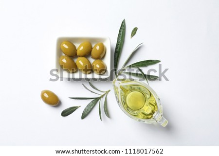 Beautiful composition with oil and ripe olives on white background