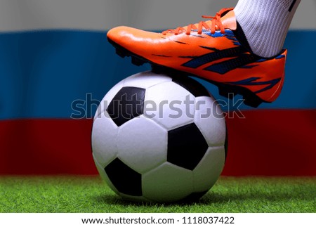 Close up legs and feet of soccer player or football player walk on green grass ready to play match on national Russian flag background.