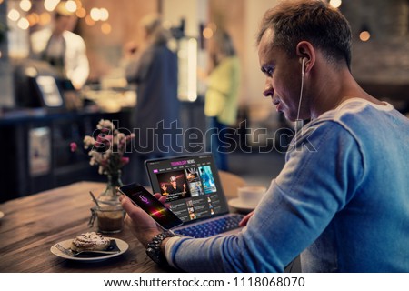 Man using modern tech while sitting in cafe Royalty-Free Stock Photo #1118068070