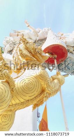 golden singha statue holding tiered and protect an angels gate at Buddha Panya temple, Thailand