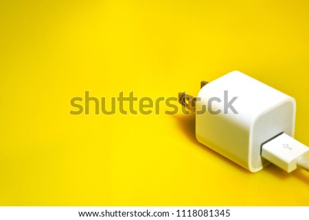 changer plug for mobile phone on yellow background, selective focus