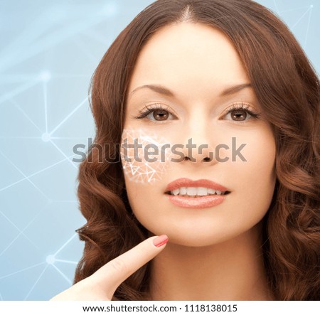beauty, technology and people concept - beautiful young woman pointing finger to her chin over blue background with low poly shape projection