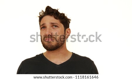 Bearded man making facial and hand gestures in front of white background