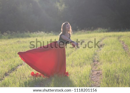 dancer in a field with a red cloth