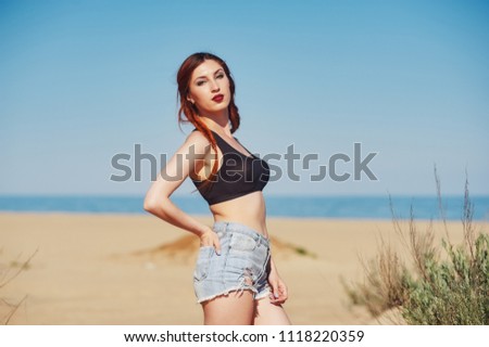Young red-haired woman on the beach