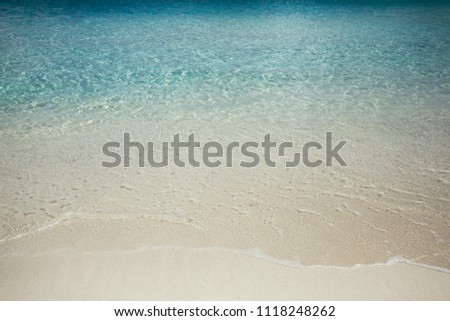 The shore of the ocean. Waves and sand of the ocean. Background. Blue water. Maldives Island. Maldive. Summer. May.