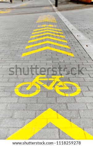 Bicycle lane sign on pedestrian side of the street