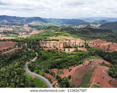 An aerial view over a country road and forest in Nakhonthai district, Phitsanulok Province, Thailand. 
