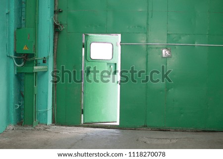 Green iron wall with half-open door