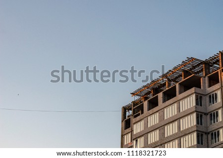 A fragment of an unfinished skyscraper against the background of the evening sky