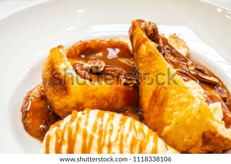 Dessert of apple pie with caramel, ice cream and soft toffee on a white plate.