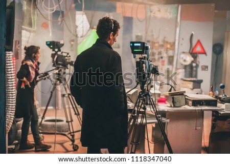 Behind the scene. Multiple camera setup. Cameraman shooting the film scene with camera in film studio. Group cinema set
