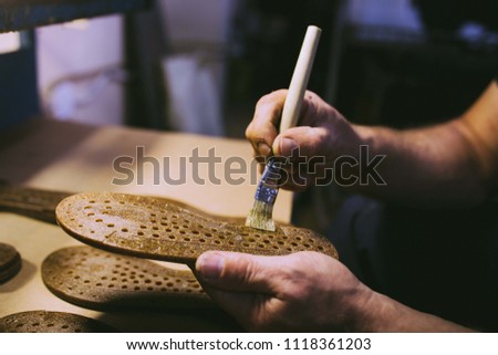 Hands making shoes. Making shoes manual. Shoemaker sitting in workshop making shoes. Footwear manufacture. Shoes factory.