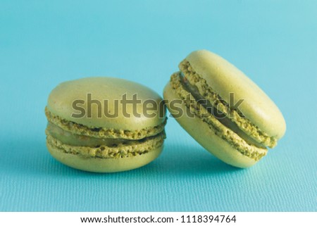 Green French Macarons on a Blue Background
