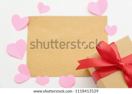 Brown blank card with paper heart shaped and gift box on white background,flat lay.