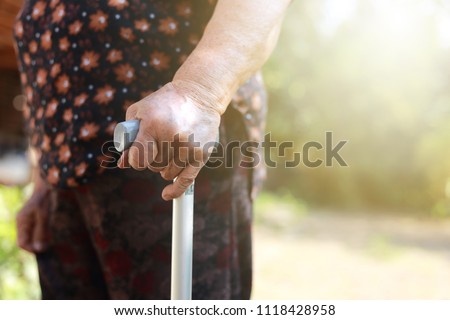 Closeup hand holding Walking stick of senior woman 