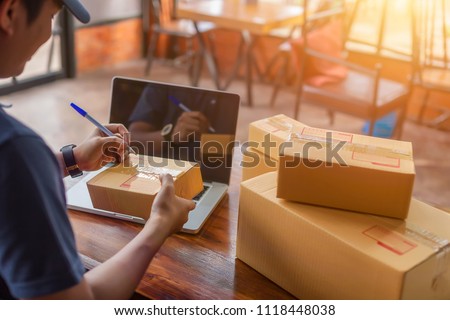 Asia delivery man are holding a cardboard box delivery to his customer.Delivery man are checking to his customer,The seller prepares the delivery box for the customer, online sales, or ecommerce. Royalty-Free Stock Photo #1118448038
