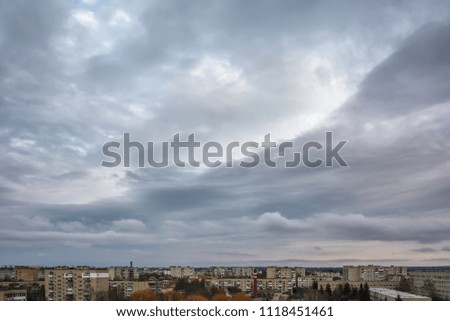 Storm clouds over city buildings at sunrise.