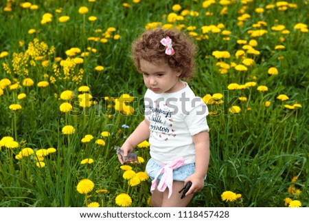 little baby girl on the meadow with daisies