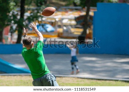 American Football Player Catching a touchdown Pass in park.
