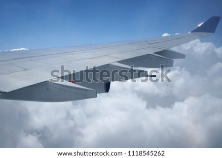 Wing of an airplane with clouds. Picture to add text message or frame for website. Traveling concept.