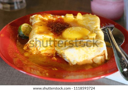 A picture of roti titab prepared for breakfast is made of bread wrap with egg add on half boiled egg on top which is popular in Sarawak and Kelantan.