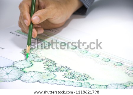 layout plan of home landscape design or garden design drawing by hand with color pencil on white paper,  focus on hand