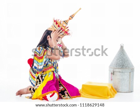 The lady in Southern thai classical dancing suit is putting the headdress on her head,sitting on white background.
