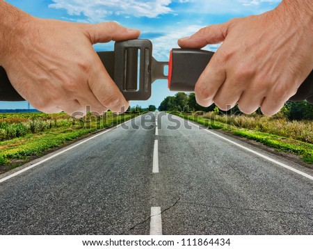 hands button safety belt on the background of the road Royalty-Free Stock Photo #111864434