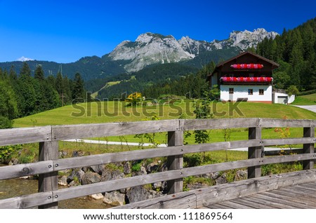 Wooden bridge in alpine village with the Alps Mountains in the background, Austria