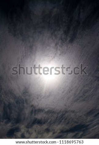 A breathtaking photograph of a thin layer of clouds (possibly Cirrus) sweeping over the sun in Winter. This photo was taken in Brisbane, Australia. 