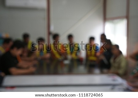 Blurred photograph of on construction site meeting with peoples who wear reflective safety jacket