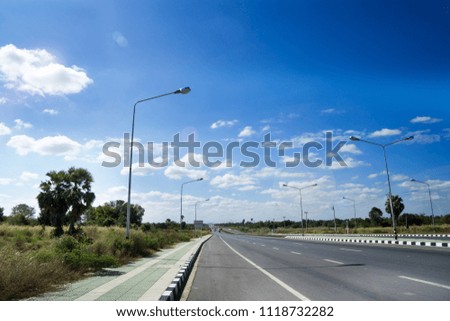Asphalt highway road with concrete walkway with wide blue sky in sunny day. Thailand.