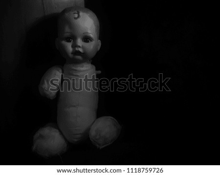 creepy doll sit in the dark room in black and white and high contrast concept