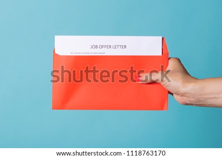 Job Offer - a letter about the successful completion of job search. A woman's hand is holding a red letter with CV. Royalty-Free Stock Photo #1118763170