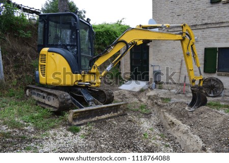 Mechanical shovel and scraper in construction site performs excavation
