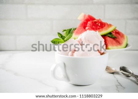 Sweet homemade Watermelon ice cream served with mint, white marble background copy space