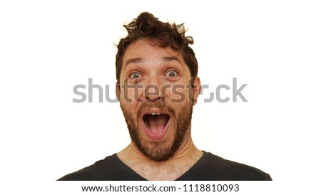 Bearded man making facial and hand gestures in front of white background                    
