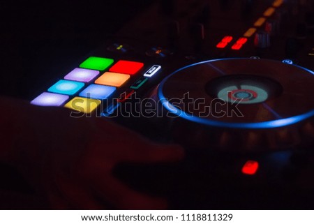DJ's hands are busy mixing electronic music on the console. The DJ music must be played to the audience. DJ have to be able to use very good control buttons. The confetti is used to enhance the party