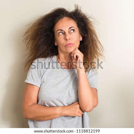 Curled hair brazilian woman serious face thinking about question, very confused idea