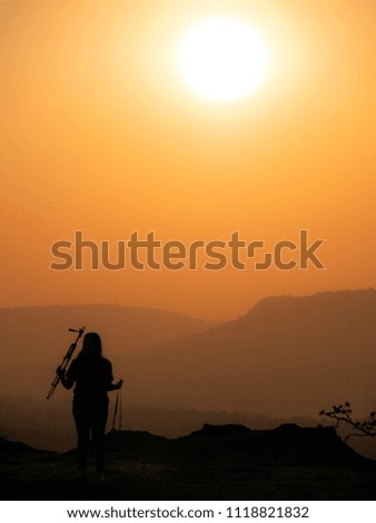 The Woman Who Holding The  Tripod and Camera in Cliff Pha Taem National Park in The Morning