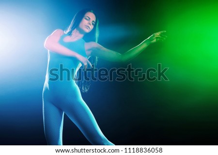 Beautiful young ballet dancer jumping on a color background.