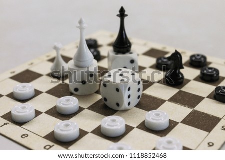 Board games. Chess, checkers, dice, lie on a vintage board. Randomly arranging composition. Light background. Blur.