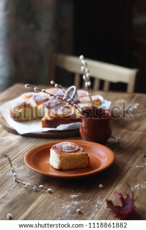Sweet Rolls with Vanilla Pastry Cream, powdered with icing sugar, on wooden table.