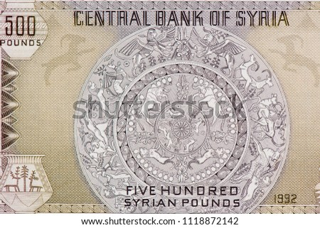 Ancient dish depicting lions, gazelles, sphinxes, bulls, goats, winged bull, man fighting lion. Cuneiform clay tablet, Stylised pottery. Portrait from Syria 500 Pounds 1986 Banknotes.