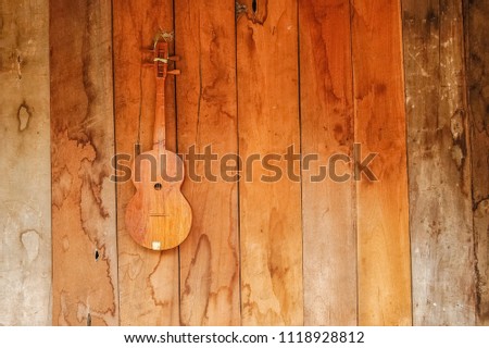 old vintage wooden longneck's guitar hand made hang on the wall, Hui Pu Kaeng Hill Tribe Village, Mae Hong Son, northern Thailand