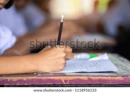 Students taking exam with stress in school classroom.